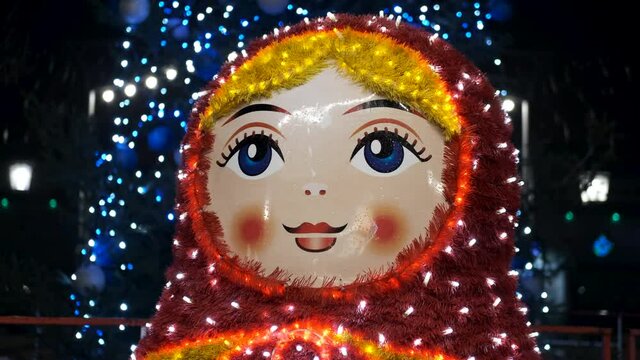 Street decoration for christmas. A large matryoshka doll in a twinkling garland.