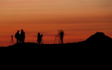 Fototapeta na wymiar Silhouettes of people in a photography workshop during sunset. Long exposure shot.