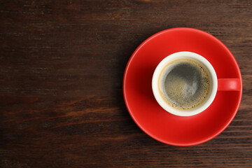 Cup of hot aromatic espresso on wooden table, top view. Space for text