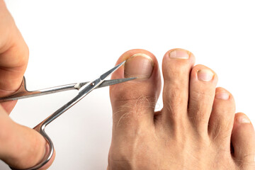 The guy cuts his toenails with scissors.