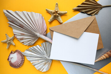 postcard mockup. craft envelope with white blank for text on yellow-gray background and dry palm leaves 