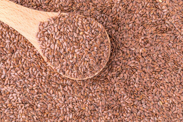 Organic food, flax seeds background, close up, flax seeds in a wooden spoon