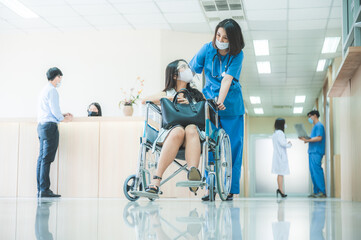 Obraz premium a doctor assistant patient on wheelchair and give a treatment consultation. wearing face mask and faceshield to protected themself from coronavirus covid-19, hospital health care concept.