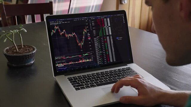 Millenial Bitcoin Crypto Cryptocurrency Investor Checking ticker screen on laptop for financial crash and bitcoin trends