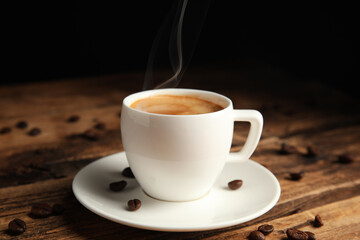 Obraz premium Cup of tasty coffee and beans on wooden table