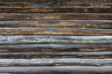 The surface of an old wooden wall made of boards darkened by time and weather. Traditional Russian...