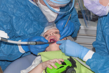 Children's dentist treats a tooth. The process of working with a dental drill