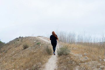 chubby woman running up hill running in sportswear. workout