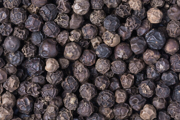 Black peppercorns background, close up, view from above, organic food