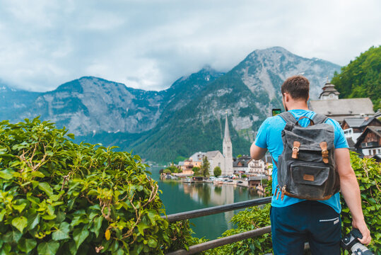 man taking picture of hallstatt city from above