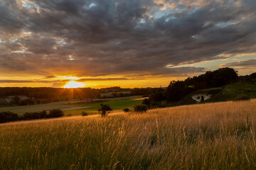 Fototapeta premium Long exposure image of an amazing sunset over the valley in Maastricht with a dramatic sky, showing amazing colors and impressive landscape views with on a view of Devils cave a former quarry