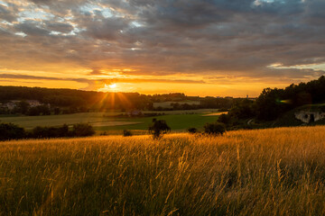 Long exposure image of an amazing sunset over the valley in Maastricht with a dramatic sky, showing amazing colors and impressive landscape views with on a view of Devils cave a former quarry