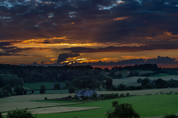Long exposure image of an amazing sunset over the valley in Maastricht with a dramatic sky, showing amazing colors and impressive landscape views with on a view of Devils cave a former quarry