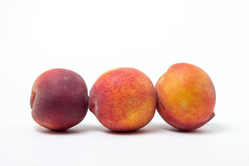 Peaches on a white background. Three ripe peaches are in a row. Healthy diet.