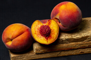 Fototapeta na wymiar Peaches on a black background. Peach cut in half. Healthy diet.