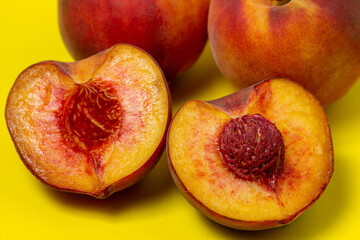 Naklejka na ściany i meble Peaches on a yellow background. Peach cut in half. Healthy diet.