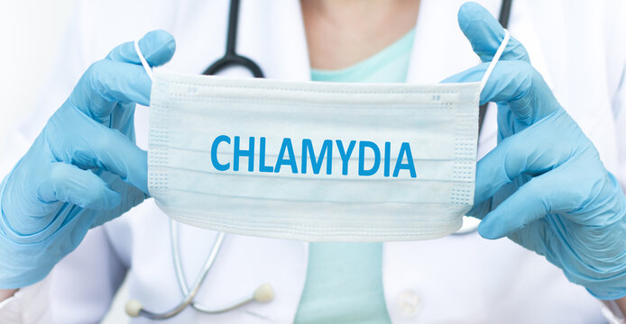 the doctor holds a disposable mask with the text CHLAMYDIA