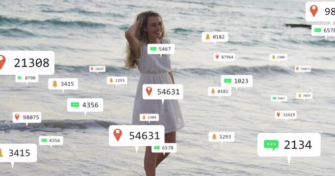 Animation of social media notifications over smiling woman on holiday paddling in the sea