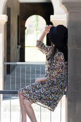 the girl is sadly sitting on the bars