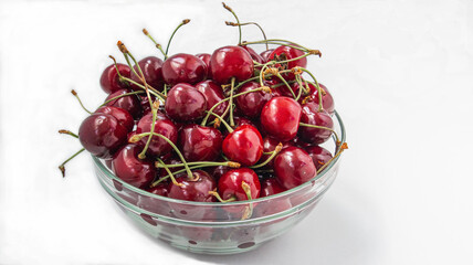 Sweet cherries in a transparent bowl on a white background
