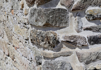A section of the wall of an ancient Roman fortification made of large blocks and stones