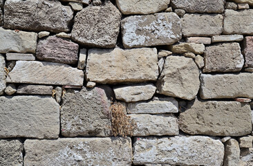 An ancient stone wall made of stones and hewn blocks.