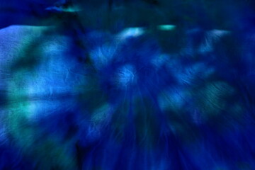 Abstract painted background. Multi-colored pattern in the shibori technique on a thin knitted fabric. Multi-color texture. batik.Textile shibori