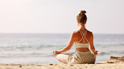 Calm woman meditating on beach at sunset