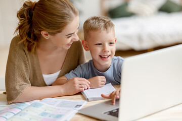 Happy mother supporting son during online studies