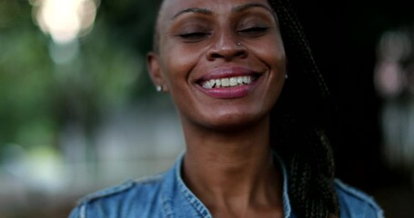 Black woman taking off covid face mask celebrating end of pandemic