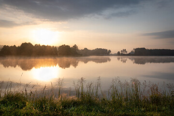Fototapeta na wymiar Beautiful sunrise at lake surrounded by forest in Krasnobród, Roztocze, Poland.