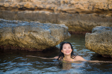 young happy and attractive Asian woman in the sea - cheerful and carefree Chinese girl playful in the water during Summer holidays trip in beautiful tropical island