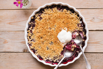 Raspberry and peach crumble on wooden table