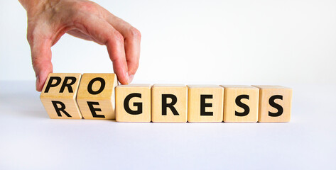 Regress or progress symbol. Businessman turns wooden cubes and changes the word 'regress' to...