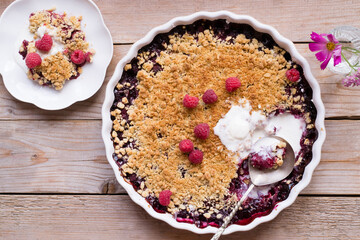 Raspberry and peach crumble on wooden table