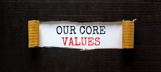 Our core values symbol. Words 'Our core values' appearing behind torn black paper. Beautiful black background. Business, our core values concept, copy space.