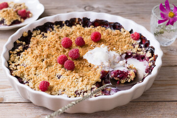 Raspberry and peach crumble on wooden table