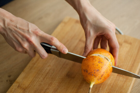 Fresh organic ripe granadilla or yellow passion fruit cut in half on a wooden board. Exotic fruits, healthy eating concept