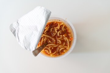 Fototapeta na wymiar Instant noodles in cup. Noodles in hot water ready to eat. Unhealthy food.