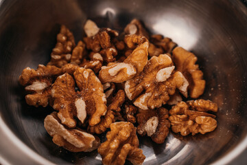 peeled walnuts in a metal cup, close-up