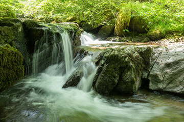 Fototapeta premium Long exposure of a waterfall on the Hoar Oak Water river at Watersmeet in Exmoor National Park