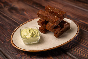 Garlic croutons with green sauce on a white plate, photo for the menu