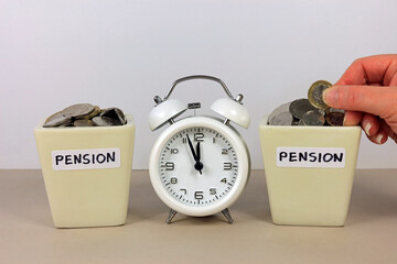 A Hand Adding A Pound Coin To A Pension Pot. Saving Money In To A Retirement Plan Before Time Runs...