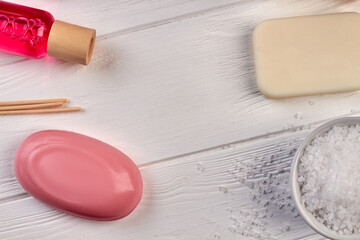 Close-up bath accessories on white wooden desk.
