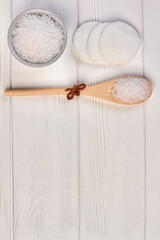 Wooden spoon with bath salt for spa and cotton pads.