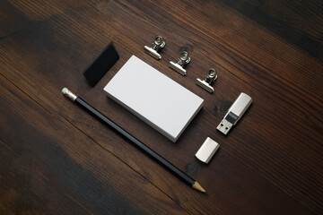 Blank corporate stationery set on wooden background. Branding mock up. Business card, flash drive, pencil and eraser.