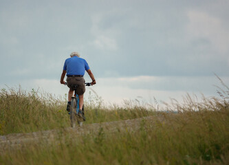 a casual cyclist on a stone track crossing salisbury plain, Wiltshire UK