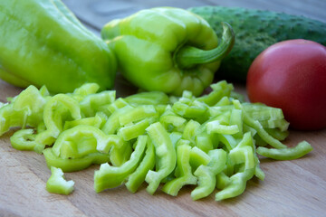 Sliced bell pepper and red tomato. Fresh vegetables for cooking lie on a wooden background.