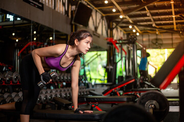 Fototapeta na wymiar Prertty sporty girl workout in the gym