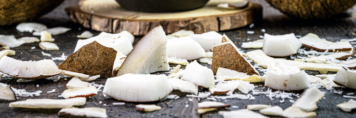 coconut pieces broken and scattered on the wooden table.